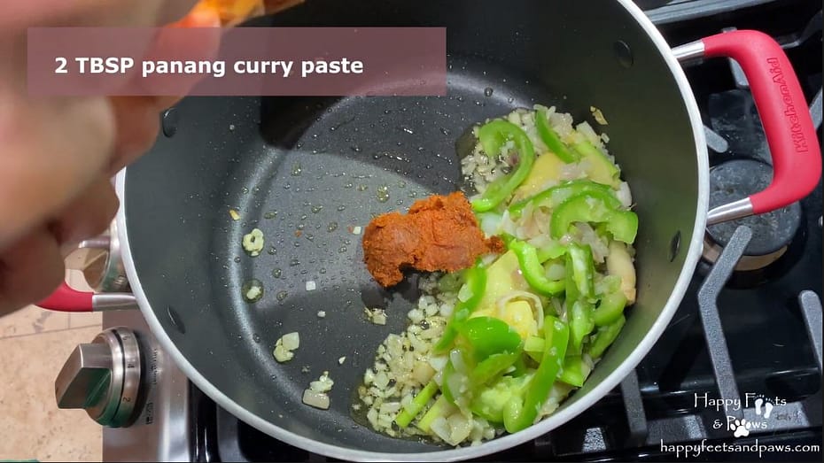 panang curry paste, ginger, green peppers in a pot cooking
