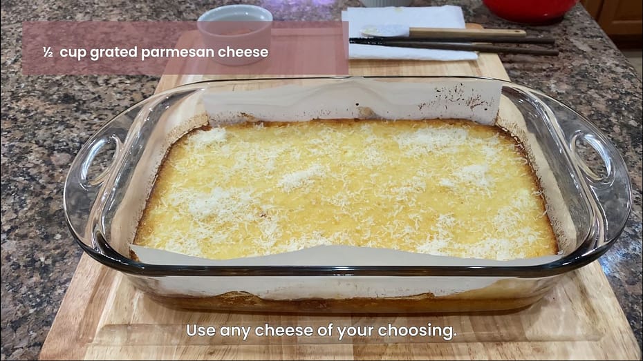 Adding grated parmesan cheese to the cassava cake