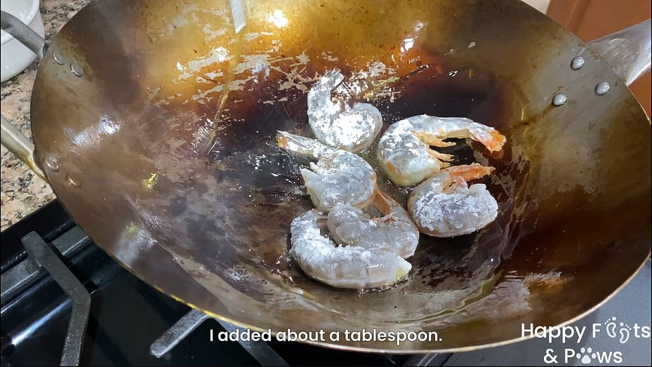Cooking shrimp in a wok with oil for Pancit Canton Recipe