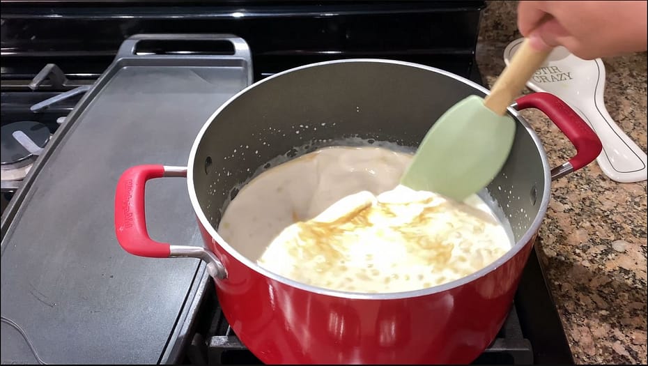 Stirring the ingredients while it cooks in a pot on a stove