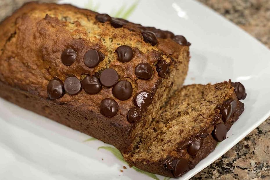 fresh baked banana bread on a plate with chocolate chips on top