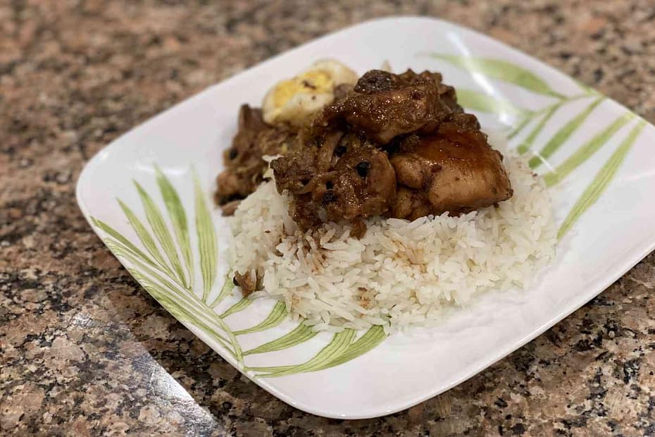 A plate with chicken, jasmin rice, eggs, and, pork filipino adobo