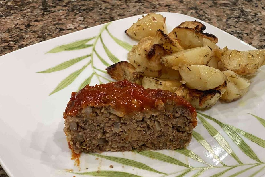 homemade meatloaf on plate with oven baked potatos