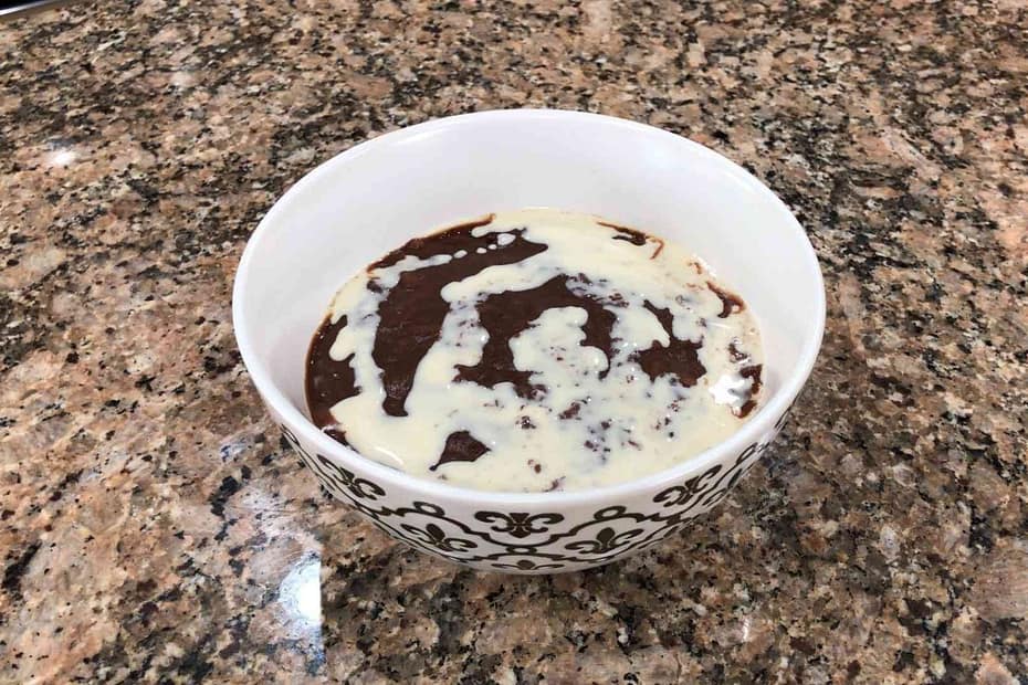 champorado in bowl with milk on top