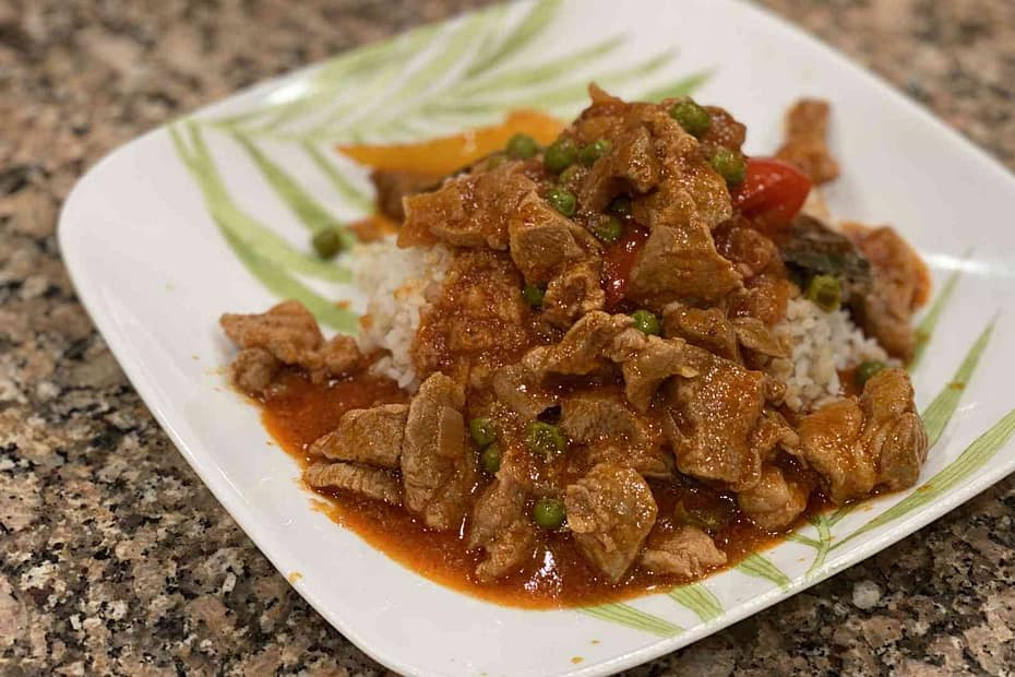 Pork Guisantes on a plate with white rice