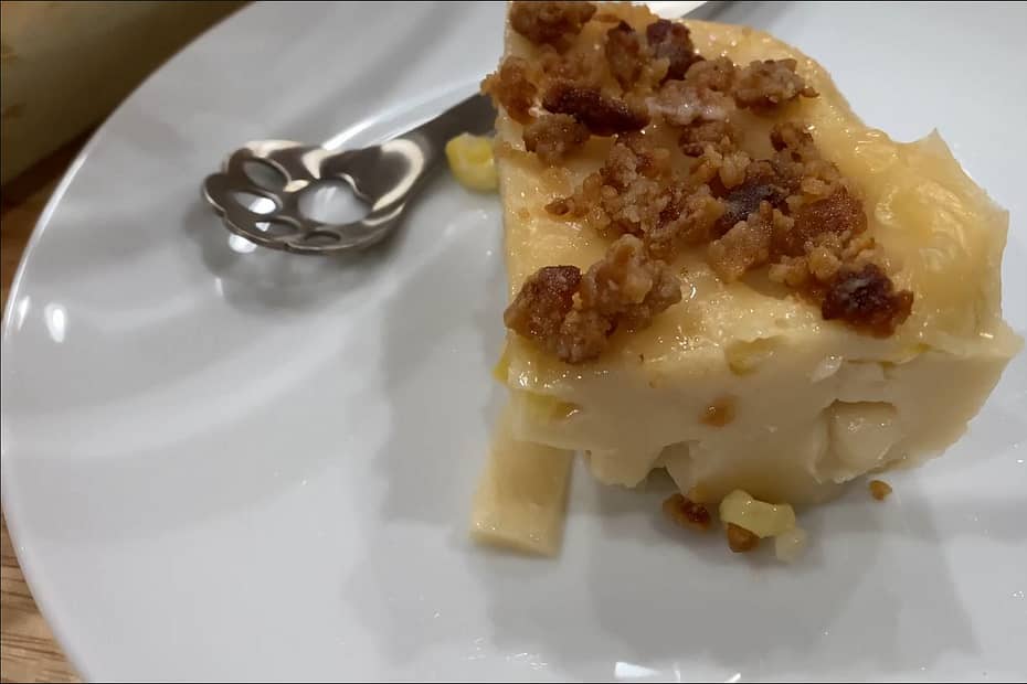 Maja Blanca slice on a plate with small spoon and latik on top