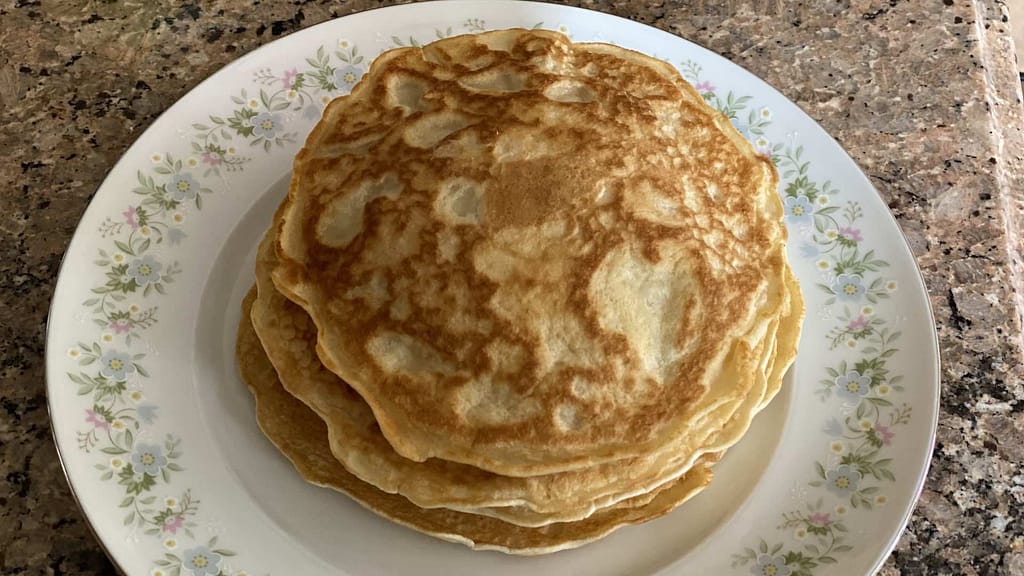 A stack of fresh homemade Filipino hotcakes on a dish with flowers