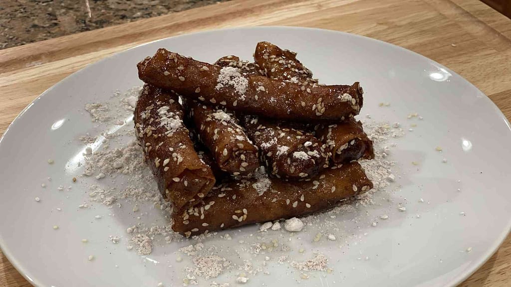 Banana Rum Rolls Stacked on a plate with powdered sugar