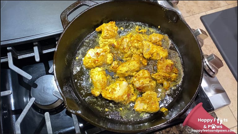 chicken being fried in a cast iron pot for chicken tikka masala recipe