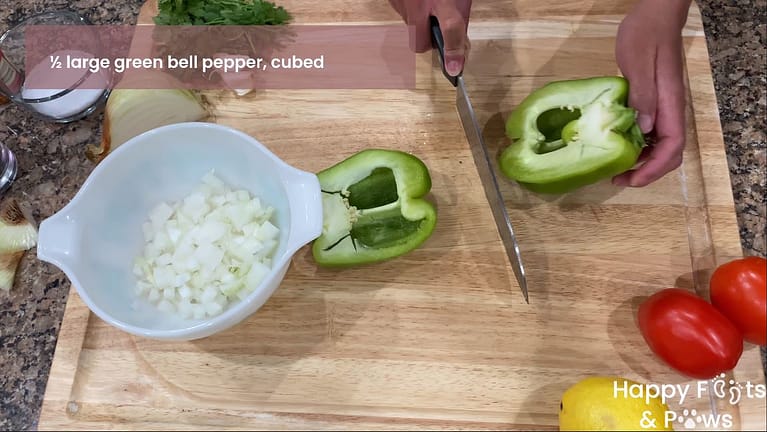 onions in a bowl with green pepper being cut on a cutting board.