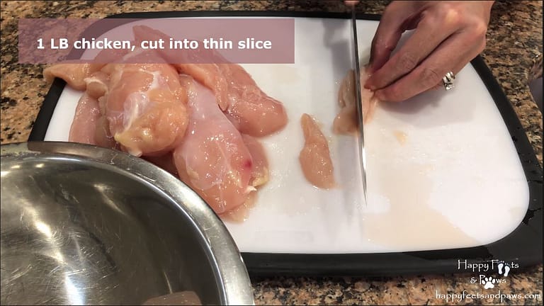 cutting chicken with a knife on a cutting board for thai chicken fried rice recipe
