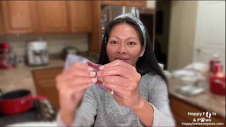 filipino woman in kitchen crushing dried red peppers in ziplock bag