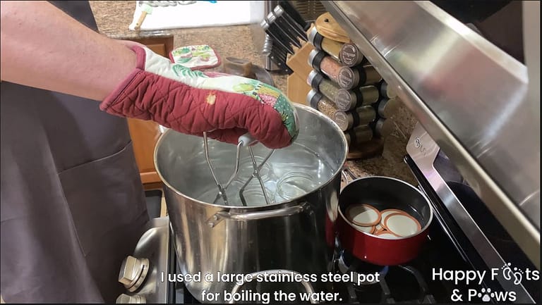 man placing mason jars in boiling water to sterilize the containers