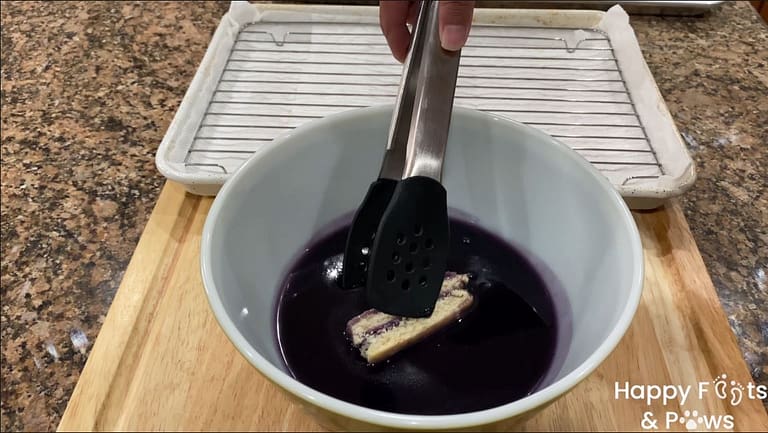 Dipping ube bread bars in ube syrup