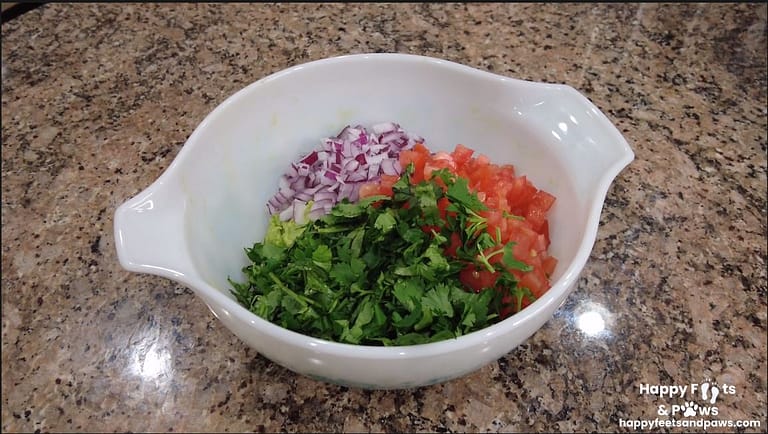 onions, cilantro, tomato in a bowl for guacomole recipe