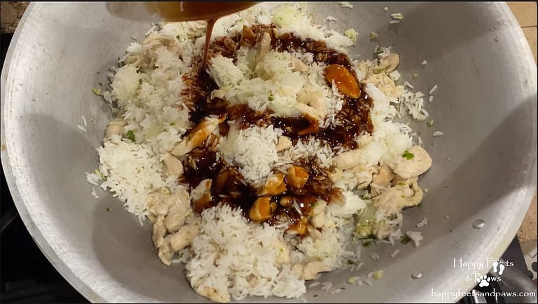 adding stir fry sauce to rice for thai chicken fried rice recipe