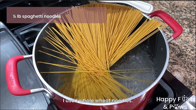 spaghetti noodles being cooked in a pot of boiling water