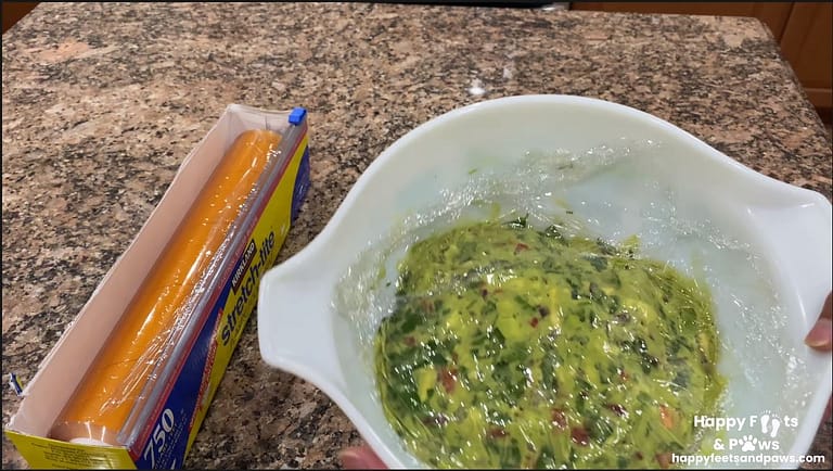 guacamole in a bowl with plastic wrap to keep it from browning