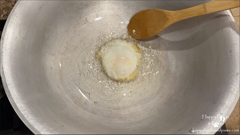 frying and egg in a wok for thai chicken fried rice recipe