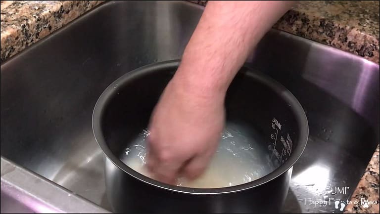 rice being rinsed in a bowl