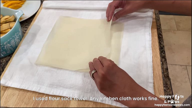egg roll wrappers on damp cloth to keep them from drying out