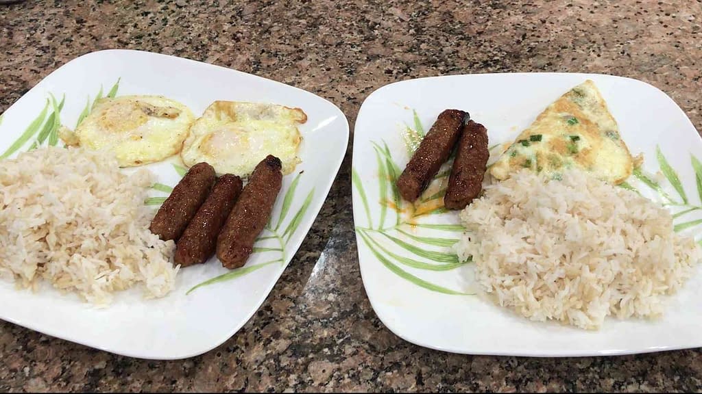 Two plates of rice with eggs Filipino Longanisa and eggs cooked.