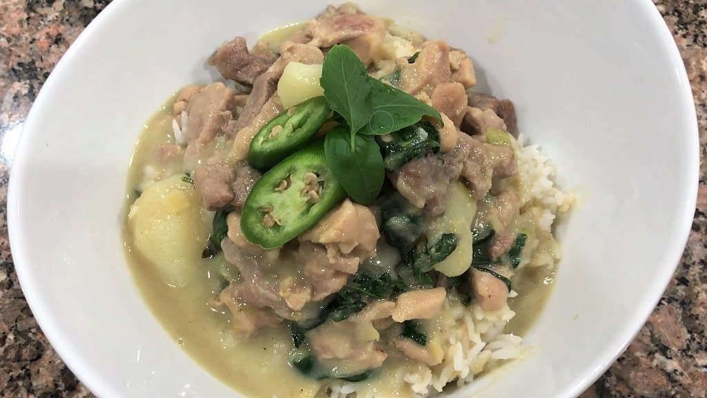 homemade thai green curry in a bowel with fresh basil and peppers