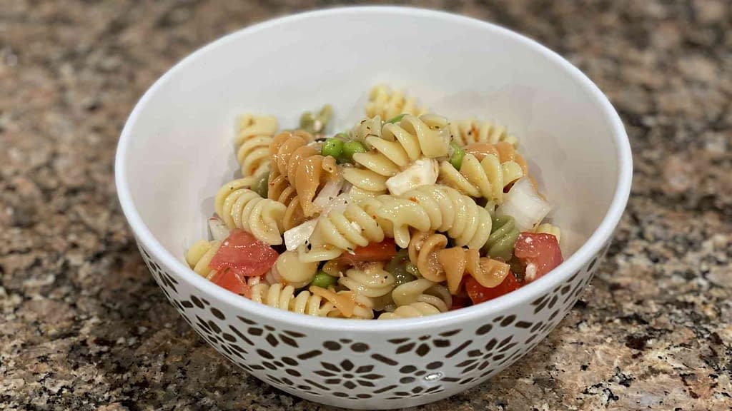 Pasta salad with onions, olives, tomato, feta cheese, and edamame.