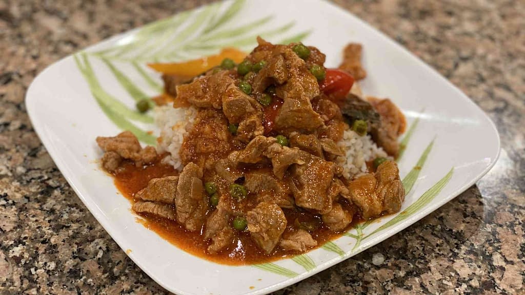 Pork Guisantes on a plate with white rice