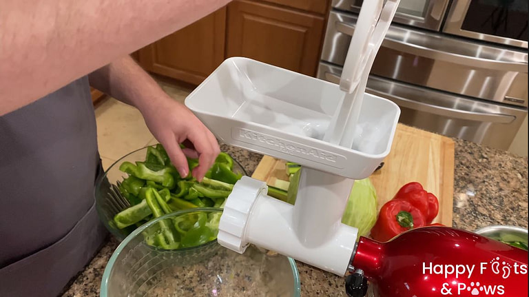 Man feeding green peppers into meat grinder for zucchini relish recipe