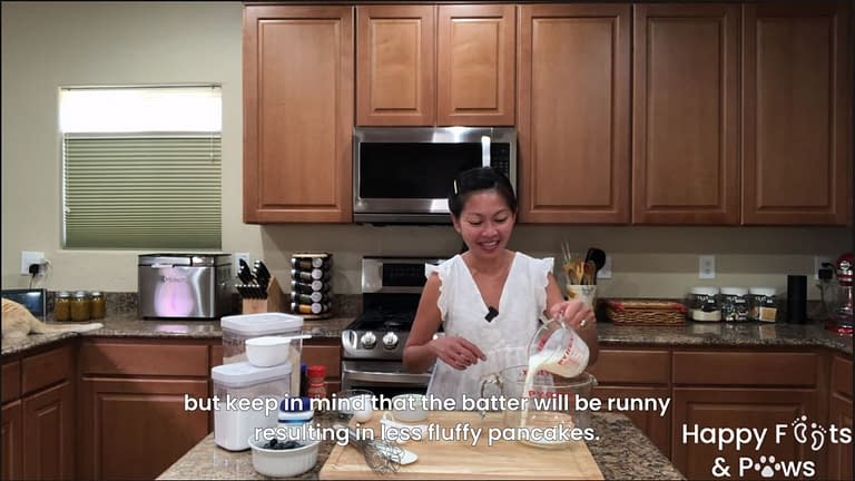 Filipino woman adding buttermilk to container for blueberry pancakes recipe