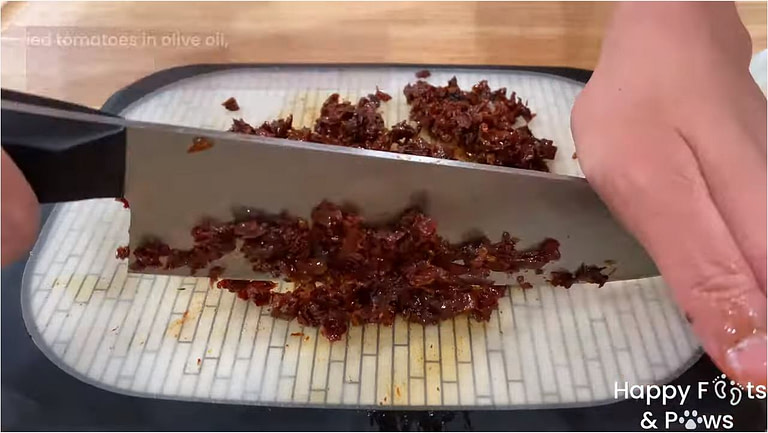 Chopping sundried tomatoes on a cutting board