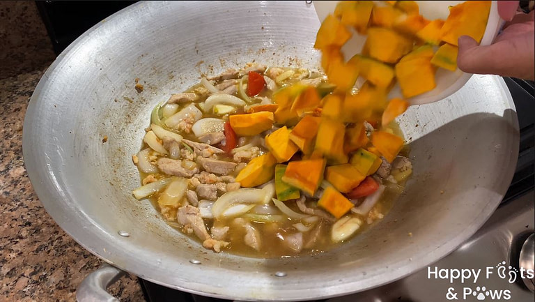 adding Squash to Pinakbet in a large wok
