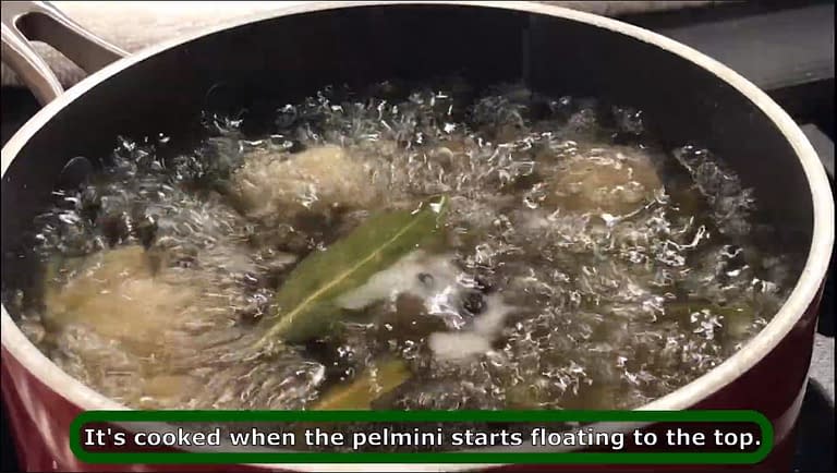 cooking pelmeni in a pot with boiling water