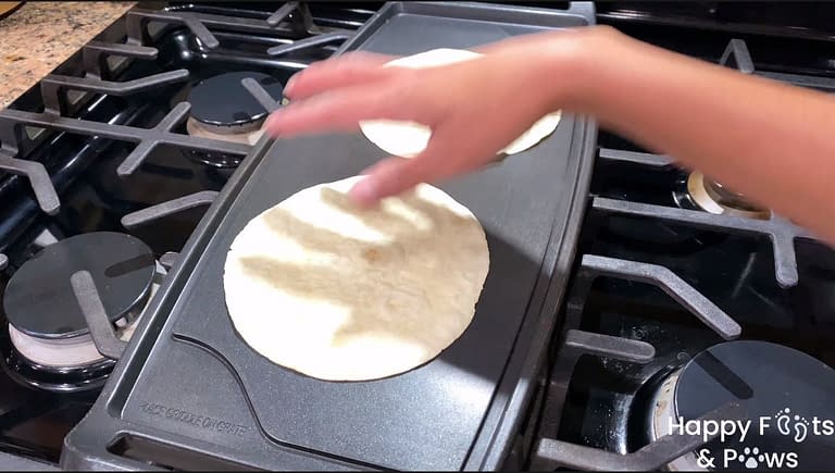 two tortillas on a skillet being warmed up